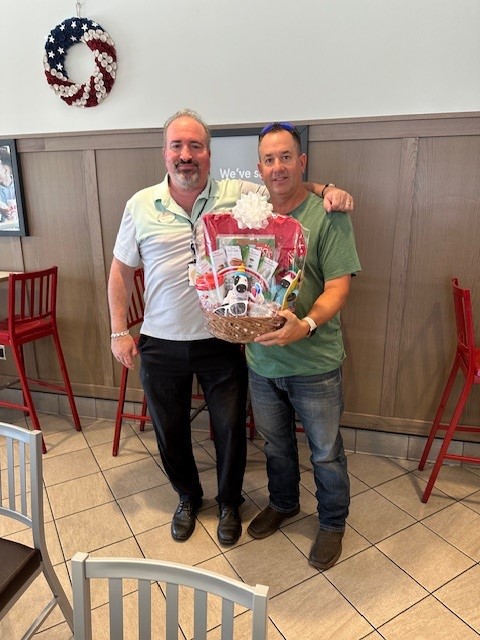 Two men holding a prize basket